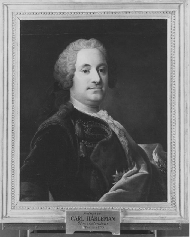 Ein Schwarz-Wei├č-Portr├Ąt eines Mannes mit ernstem Gesichtsausdruck, der einen langen dunklen Mantel mit hohem Kragen und Manschetten tr├Ągt und die H├Ąnde vor der Brust verschr├Ąnkt hat, dunkles Haar und fokussierte Augen.