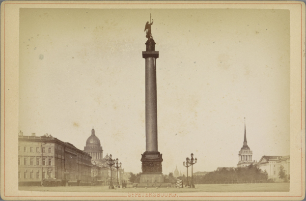 Altes Schwarz-Weiß-Foto eines Denkmals in einem städtischen Platz mit umgebenen Gebäuden, Straßenlaternen, Bäumen und einem klaren Himmel; Text erscheint unten.