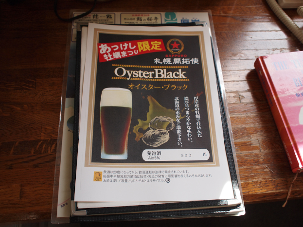 Plakate auf einem Tisch mit einem Buch rechts daneben.