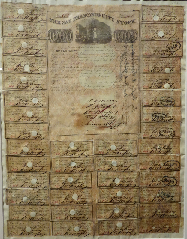 Ein altes Aktienzertifikat mit zahlreichen Unterschriften, Texten und Zahlen darauf.