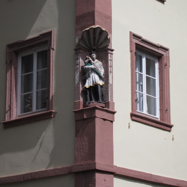 Ein Gebäude mit Fenstern und einer Skulptur davor.