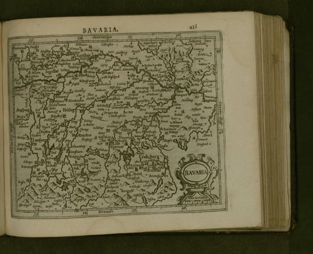 Offenes Buch mit detaillierter Karte von Bayern mit beschrifteten Städten und Dörfern, begleitet von beschreibendem Text.