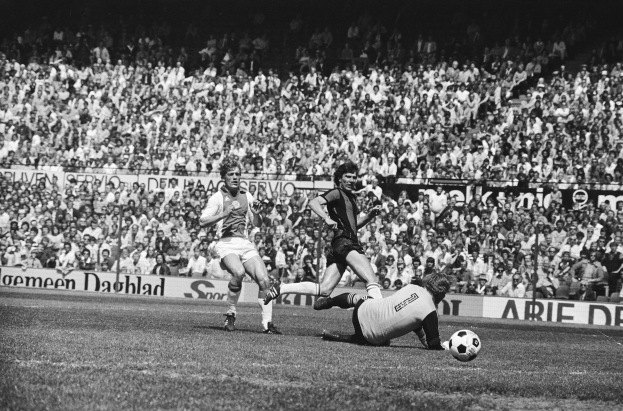 Schwarzes Bild von Männern, die auf einem Feld Fußball spielen, mit Zuschauern im Hintergrund und einer Tafel mit der Aufschrift "Bundesliga 1978-79 Ajax 1-1 Hannover 96."
