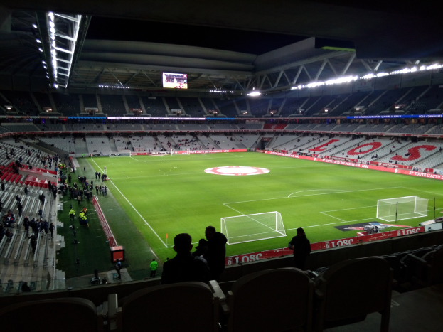 Großes Stadion voller Zuschauer bei einem Fussballspiel im Estadio Santiago Bernabeu in Madrid, Spanien, unter Stadionbeleuchtung mit einem Bildschirm oben.