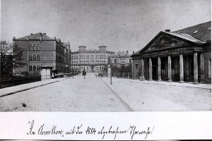 Ein Schwarz-Weiß-Foto einer Stadtstraße mit Gebäuden, Bäumen, Pfählen, Menschen und einer Straße, mit dem Text "1884 – die Königliche Akademie der Künste, London" unten.
