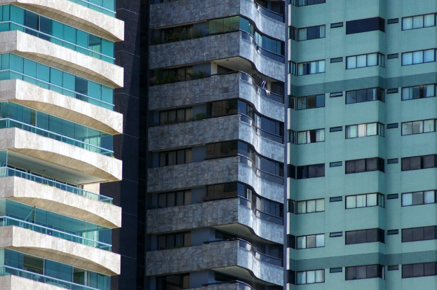 Mehrere Gebäude in verschiedenen Höhen und Designs sind in einer urbanen Umgebung zu sehen.