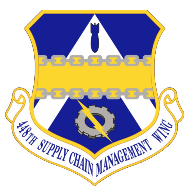 Logo des 48. Versorgungsmanagementgeschwader mit einem blauen Schild mit einem weißen Stern und einem weißen Banner mit der Aufschrift "Versorgungsmanagement" in blau, alles von einem weißen Rand mit der schwarzen Schrift "48. Versorgungsmanagementgeschwader" umgeben.