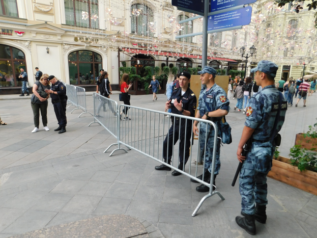 Polizisten vor einer Menschenmenge, einige mit Waffen, mit Absperrungen und Schildern im Vordergrund während einer Anti-Terror-Operation in Wien, Österreich.