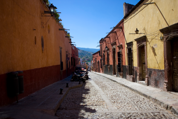 Eine leere Straße mit zahlreichen geparkten Fahrrädern, umgeben von mehreren Gebäuden, mit einem prominenten Gebäude im Vordergrund.