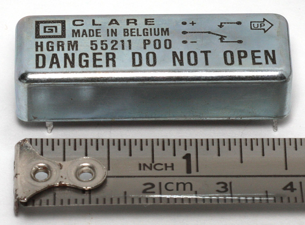 Metallbox beschriftet mit "Danger Do Not Open" neben einer Lineale auf einer weißen Oberfläche.
