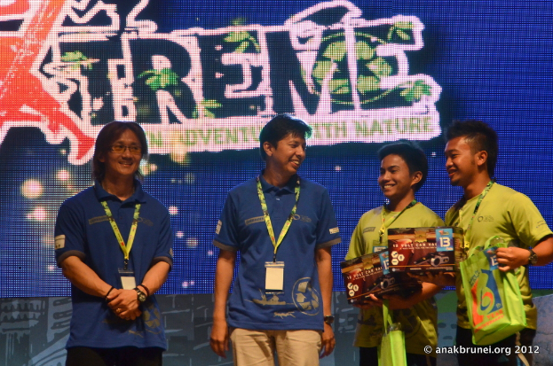 Menschen mit Ausweisen, ein Plakat im Hintergrund.