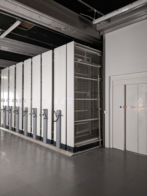 Ein großer Raum voller Numerous Server, mit einem Boden, einer Wand auf der rechten Seite und einer Decke mit Lampen oben, was auf ein Data Center hinweist.