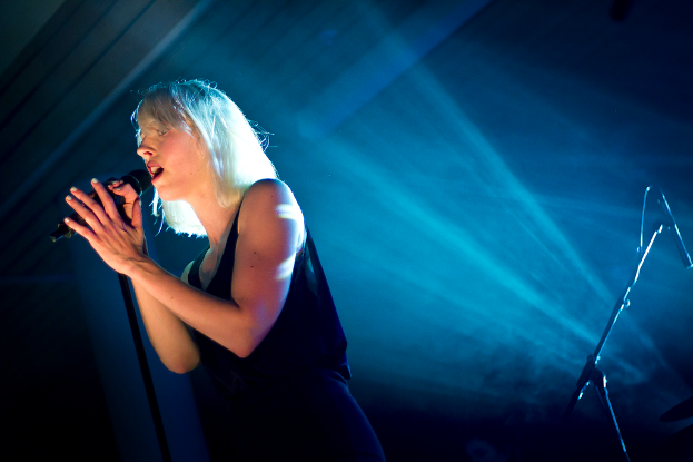 Eine Frau singt in ein Mikrofon.