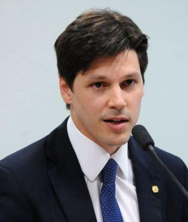 Ein Mann im Anzug und Krawatte spricht in ein Mikrofon, wahrscheinlich um die Genehmigung eines Gesetzes durch die Regierung zu verkünden.