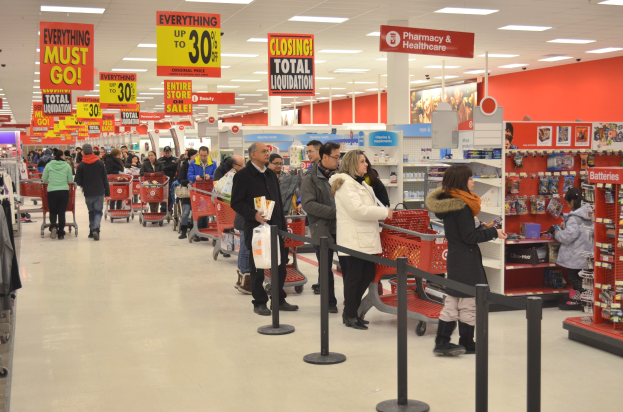 Ein überfüllter Walmart-Laden an Black Friday, mit Einkaufswagen schiebenden Kunden, umgeben von Regalen, Informationsschildern und Deckenleuchten.