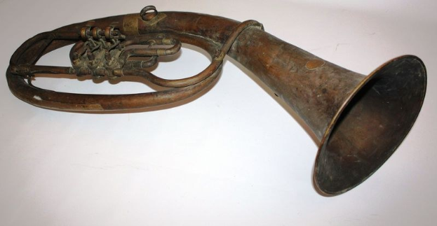 Ein glänzendes Messinghorn mit kunstvollen Gravuren, das einen gebogenen Hals und eine breite, aufgeweitete Mündung hat und auf einem weißen Hintergrund dargestellt ist.