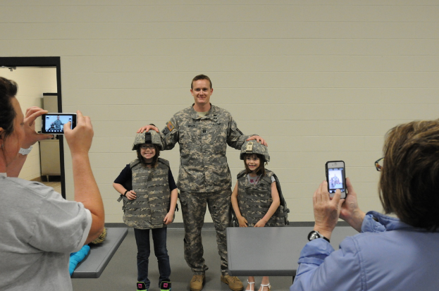 Eine Gruppe von Menschen, die stehen, wobei einige wenige Mobiltelefone halten.