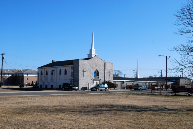Eine Stadtansicht mit zahlreichen Gebäuden, Autos auf der Straße und Bäumen am Boden.