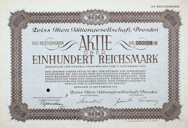 Ein altes deutsches Aktienzertifikat mit schwarzem Rand und der Aufschrift 'Aktie über Einhundert Reichmark'