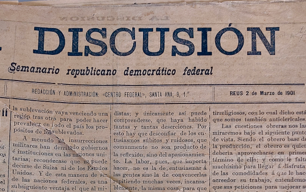 Eine gelbliche, leicht zerknitterte Zeitung mit der schwarzen Aufschrift 'Diskussion', auf der der Titel 'Semanario Repúblicano Democrático Federal' steht.