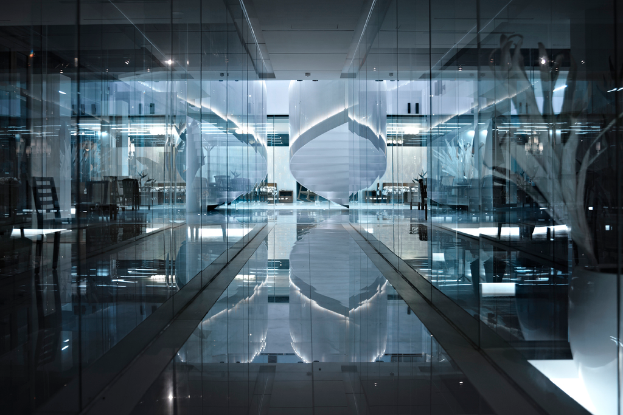 Das Innere eines Gebäudes mit Stühlen, Lampen und Glastüren, mit einem sichtbaren Boden am unteren Bildrand.