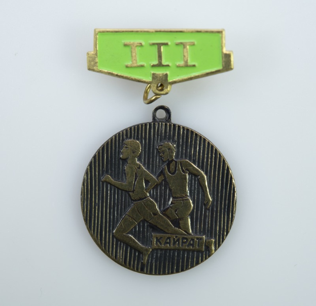 Eine Bronzemedaille mit einem grünen Band, das zwei Läufer zeigt und mit Text beschriftet ist.