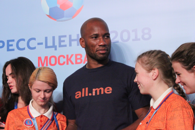 Gruppe von Menschen auf einer Bühne, die Medaillen halten, mit einem Banner mit Text und einem Fußball im Hintergrund, das die 2018 FIFA-Weltmeisterschaft Russland anzeigt.