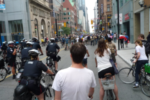 Geb√§ude säumen eine Straße, auf der einige Menschen Fahrräder fahren.