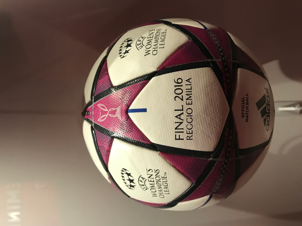 Ein weißer Fußball mit schwarzen und pinken Akzenten liegt auf einem hellen Holztisch, mit der Aufschrift "UEFA Women's Champions League Final 2016".