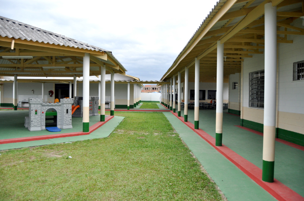 Schutzhütten mit Säulen und Räumen, umgeben von einer Grasfläche.